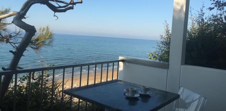 Vista mare da un balcone con due tazzine di caffè.